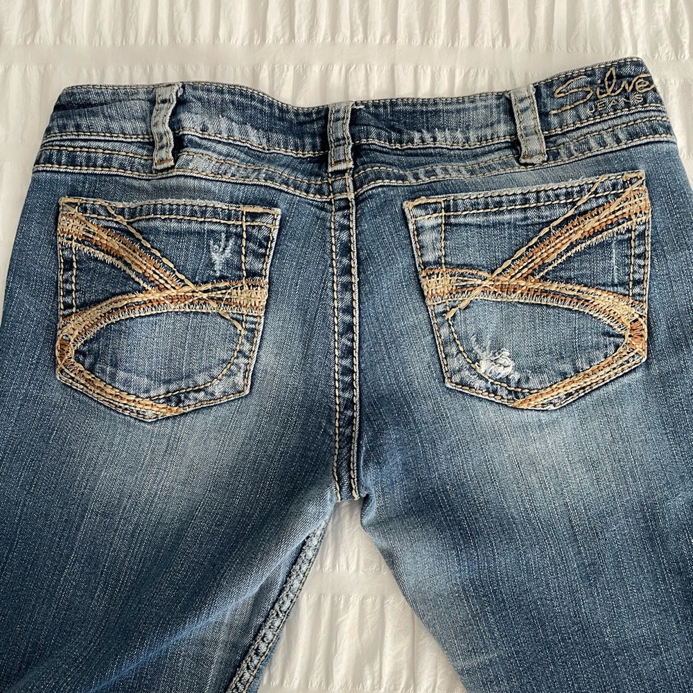 Silver Twisted distressed denim boot cut mid rise jeans.